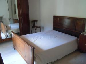 een slaapkamer met een houten bed en een spiegel bij MAISON AUGUY in Saint-Julien-Boutières