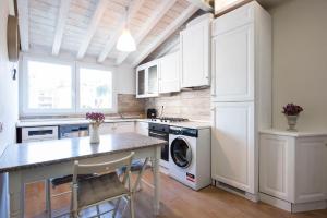a kitchen with white cabinets and a washer and dryer at 99 Via Esino in Ancona