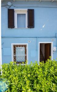 a blue building with two windows and a staircase at 99 Via Esino in Ancona