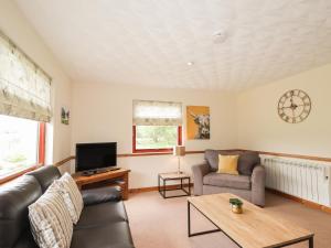a living room with a couch and a tv at Rowan Bank in Spean Bridge