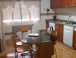 Casa do Norte في سان سالفادور: مطبخ مع طاولة وكراسي ومغسلة