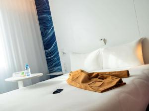 a brown bag sitting on top of a bed at ibis Styles Paris Orly Airport in Paray-Vieille-Poste