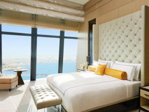 a hotel room with two beds and a large window at Fairmont Baku, Flame Towers in Baku