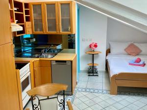 a small kitchen with a bed and a sink at Apartments Igor in Piran