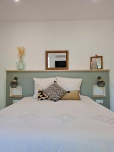 1 dormitorio con cama blanca y espejo en la pared en Chambres d'hôte Casprese en Altiani