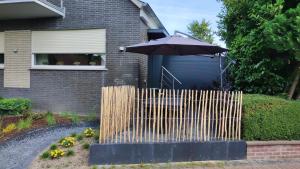 a fence with an umbrella in front of a house at Ferienwohnung Xantener Südsee in Xanten
