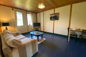 een woonkamer met een witte bank en een tafel bij The Cosy Cabin in Swinford