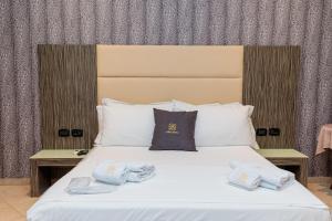 een slaapkamer met een bed met handdoeken erop bij Hotel Aliko in Vlorë