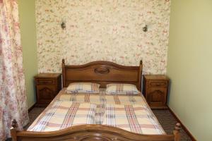 - une chambre avec un lit en bois et 2 oreillers dans l'établissement Уютнейший мини-отель "Rosky", à Yasinya