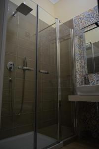 una ducha con una puerta de cristal junto a un lavabo en Palazzo Gioffrè, en Gela