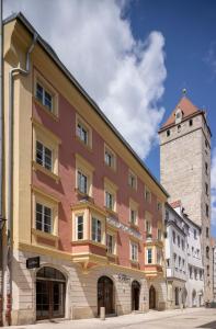 a building on a street with a clock tower at Altstadthotel der Patrizier in Regensburg