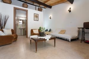ein Wohnzimmer mit einem Sofa und einem Tisch in der Unterkunft La Casa Cottage in Chania
