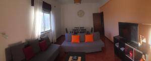 a living room with a couch with orange pillows at Spacious Central 2 Bedroom Apartment in Setúbal