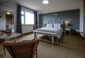 BlueTit Lodge في كيلكي: غرفة نوم بسرير وطاولة وكراسي
