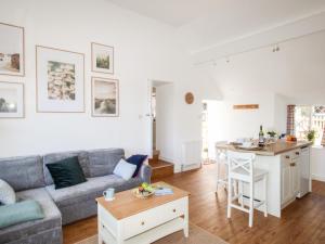 a living room with a couch and a table at Sea Pink Cottage in Swanage
