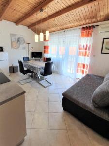 a kitchen and a living room with a table and chairs at Apartments Angela in Kampor