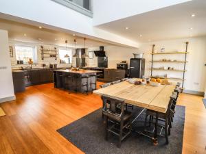 a large kitchen with a wooden table and chairs at The Old Sunday School in Lydney