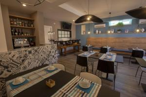 a restaurant with tables and chairs and a bar at Luxmarì Hotel & Spa in Castellammare del Golfo