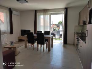 cocina y comedor con mesa y sillas en Sweet Home Apartments, en Sárvár