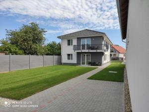 una gran casa blanca con un patio de césped en Sweet Home Apartments, en Sárvár