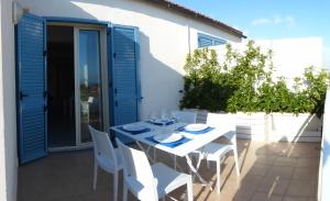 einen weißen Tisch und Stühle auf einer Terrasse in der Unterkunft siciliacasevacanze - Ulivi in Marina di Ragusa