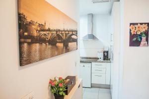 a kitchen with a painting of a bridge on the wall at RentalSevilla De paseo por los Remedios in Seville