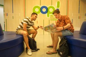 Due uomini seduti sui sedili che guardano una mappa di POP! Hotel Sangaji Yogyakarta a Yogyakarta