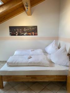 a bed with white sheets and pillows in a room at Ferienwohnung Juliane in Holzkirchen