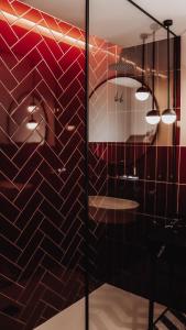uma casa de banho com uma parede de azulejos vermelhos e pretos em JovA Hotel Boutique em El Campello