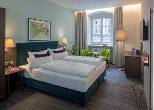 a hotel room with a large bed and a television at Altstadthotel der Patrizier in Regensburg