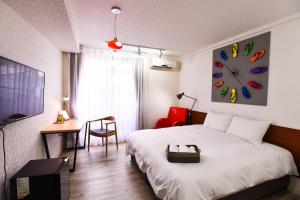 台南的住宿－Rainbow Island，卧室配有一张床,墙上挂着一个钟