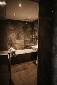 a bathroom with a tub and a sink and a mirror at Shieldaig Lodge Hotel in Gairloch