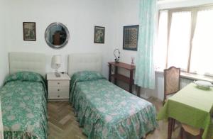 een slaapkamer met 2 bedden, een tafel en een spiegel bij Maison Dory in Pescara