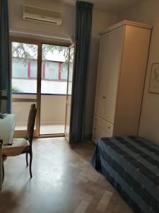 een slaapkamer met een bed, een bureau en een raam bij Maison Dory in Pescara