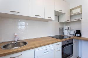 a kitchen with white cabinets and a sink at Apartment Jano in Baška