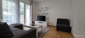a living room with a couch and a table and a television at Apartman Rosić in Trebinje