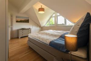 Un dormitorio con una cama grande en un ático. en Strandkrabbe, en Hohwacht