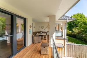 una casa con terraza con mesa y sillas en Strandkrabbe, en Hohwacht
