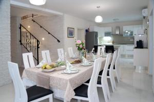 uma sala de jantar com uma mesa e cadeiras brancas em Villa Afrodita em Lećevica