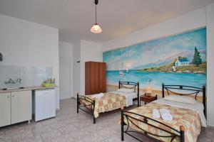 a room with two beds and a painting on the wall at KIPRIANOS - STUDIOS in Loutra Edipsou +21 photos