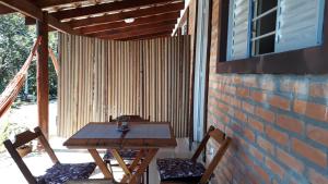 a wooden table and two chairs on a patio at Casa Studio Uirá em Chapada dos Guimarães in Chapada dos Guimarães