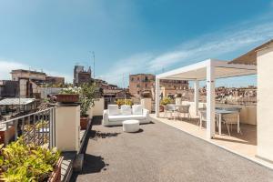 a patio with a white couch and a table on a roof at Nikis Collection Navona in Rome
