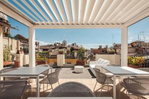 a patio with tables and chairs and a view of the city at Nikis Collection Navona in Rome