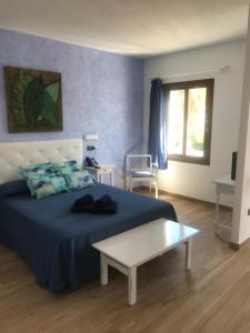 a bedroom with a bed and a table in it at Apartamentos El Bergantin Menorca Club in Fornells