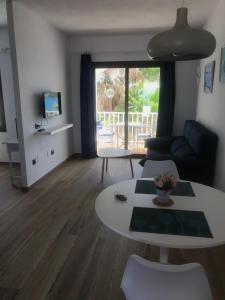 a living room with a table and a couch at Apartamentos El Bergantin Menorca Club in Fornells
