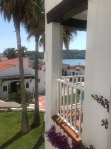 a view from the balcony of a house with palm trees at Apartamentos El Bergantin Menorca Club in Fornells
