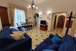 a living room with a blue couch and a dining room at Profumo di Limoni in Minori