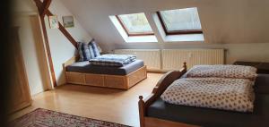 a attic room with two beds and a window at Apartmenthaus Am Schlosspark in Schkopau