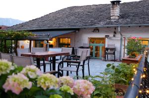 a patio with tables and chairs in front of a house at Stone City Hostel in Gjirokastër