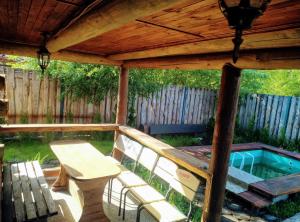 a patio with a wooden pergola and a table and bench at Котедж ,,Чудовий"з банькою in Novaya Greblya